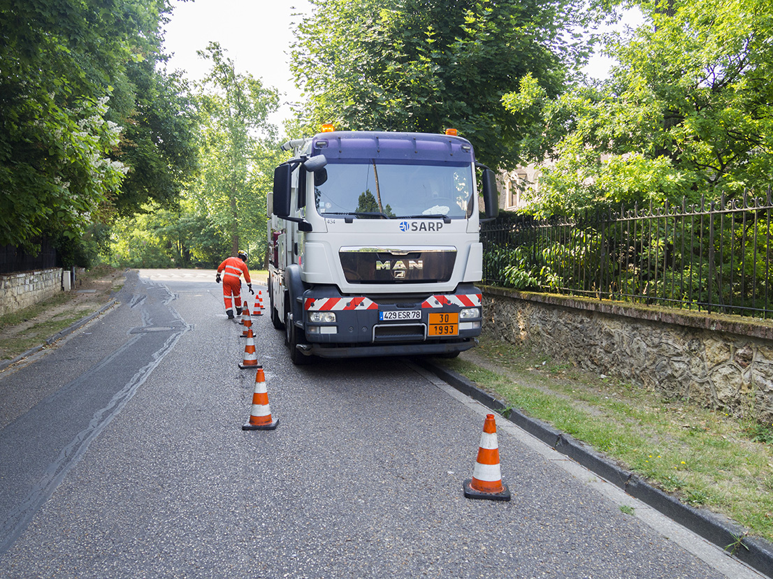 homme près d'un camion déposant des plots de sécurité